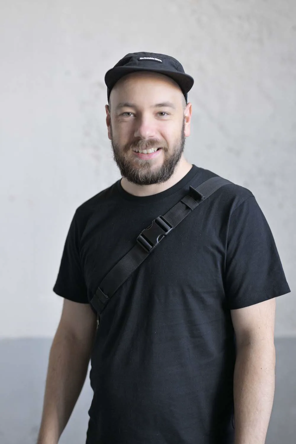 Christoph Döberl in schwarzem T-Shirt und Kappe vor einer hellen Wand